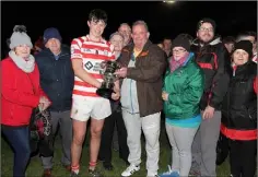  ??  ?? Aidan Murray presenting the Larry Murray Memorial Cup to Ferns St. Aidan’s captain Eoin Murphy, with members of the Murray family looking on.