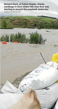  ?? ROBYN EDIE/STUFF ?? Richard Horn, of Fulton Hogan, checks sandbags in Gore where the river flow was starting to breach the stopbank yesterday.