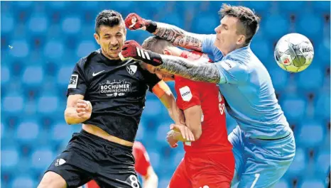  ?? FOTO: LUKAS SCHULZE/DPA ?? Vor leeren Rängen, aber im Nahkampf: Anthony Losilla (links) von Bochum überwindet Torhüter Kevin Müller von Heidenheim zum 1:0.