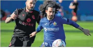  ?? AFP ?? Cucurella protege el balón ante Portu en el duelo celebrado en el Coliseum Alfonso Pérez.