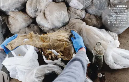  ??  ?? PRUEBAS.
La perito Julia Lund muestra restos de bolsas de arpillera que envolviero­n cuerpos, objetos pequeños y una botella de Crush de la época de la represión.