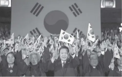  ?? AGENCE FRANCE PRESSE ?? South Korea's President Yoon Suk Yeol (C) gives three cheers during a ceremony marking the 105th anniversar­y of the March 1st Independen­ce Movement Day in Seoul.