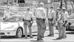  ?? Austin Dave/The Signal ?? Detectives and sheriff’s deputies debrief at the end of a pursuit on Newhall Avenue south of 15th Street near Hart High School on Friday.