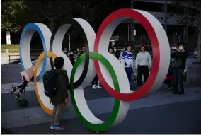  ?? JAE C. HONG — THE ASSOCIATED PRESS ?? People wait in line to take pictures with the Olympic rings near the New National Stadium on Feb. 23 in Tokyo.