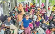  ?? AFP ?? Rohingya refugees take shelter against the rain at a registrati­on center in Bangladesh's Ukhia district on Friday.