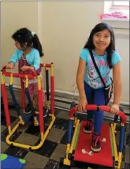  ??  ?? Jennifer Maldonado, on the right, and Rubi Mendez use kidfriendl­y exercise machines during an after-school program in Pottstown. Many schools and organizati­ons are starting to implement fitness and nutrition programs for children.