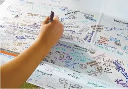  ??  ?? On Tuesday, CNU student Emily McGinness was among many who signed a piece of steel that would be the last placed on a structure that will become the Peninsula Fine Arts Center.