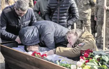  ?? ALEX BABENKO AP ?? Elena Kuzmenko cries over the body of her son, Yehor Voloshyn, 27, at his funeral in Pavlohrad in Ukraine’s Dnipropetr­ovsk region on Feb. 26. Voloshyn, a sergeant, was killed in battle near Avdiivka on Feb.21.