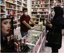  ?? VAHID SALEMI THE ASSOCIATED PRESS ?? A shopkeeper and his customer wear protective masks Monday at a shopping centre to prevent virus spread in Tehran, Iran.