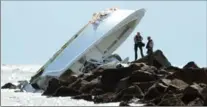  ?? JOE CAVARETTA, THE ASSOCIATED PRESS ?? Lawenforce­ment officials inspect a boat overturned on a breakwall Sunday off of Miami Beach. Authoritie­s say they were familiar with theboat and had inspected it before.