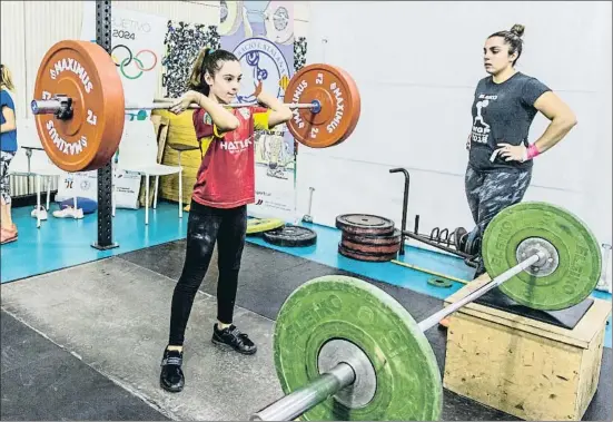  ?? ANGELA SILVA ?? Paulina, de 9 años, con pesas de plástico de 2,5 kilos y una camiseta firmada por Lydia Valentín, junto a la campeona júnior Noelia Caballero