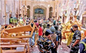  ?? Pic by Amila Gamage ?? Police and military officers inspecting the Katuwapiti­ya Church after the blast.