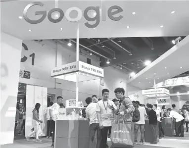  ?? AGENCE FRANCE-PRESSE VIA GETTY IMAGES ?? Visitors gathering at Google booth during the 2016 China Internatio­nal Electronic Commerce Expo earlier this month. Though CEO Sundar Pichai touted AI as the future, Google is lagging on bots technology.