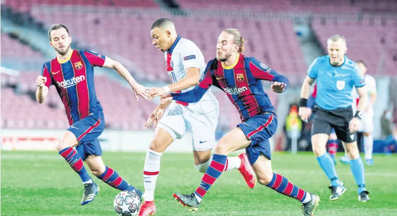  ?? AP ?? PSG’s Kylian Mbappe (centre) fights for the ball with Barcelona’s Oscar Mingueza (right) during the Champions League round of 16, first-leg match between FC Barcelona and Paris Saint-Germain at the Camp Nou stadium in Barcelona, Spain, yesterday. PSG won 4-1.