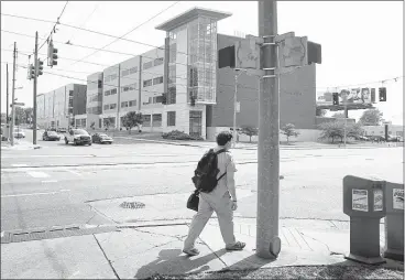  ?? MARK WEBER/THE COMMERCIAL APPEAL ?? A single pedestrian walks on Madison near the Universit y of Tennessee Health Science Center’s new Cancer Research building in the cit y’s medical district. The district’s nine CEOs have hired planner Omar Blaik to help bring more curb appeal to the...