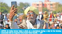  ??  ?? JAIPUR: An Indian farmer takes a photo on a smartphone during a rally for the farming community held by Congress Party leader Rahul Gandhi. — AFP