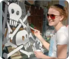  ??  ?? Sarah Kaizar of Richboro creates a bone yard on the front window at Allegheny Art.