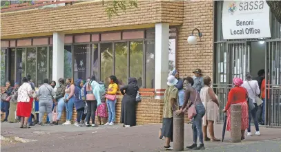  ?? Picture: Neil McCartney ?? HELPING HAND. People queue for government grants outside the Benoni Sassa offices.