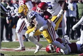  ?? MICHAEL WOODS — THE ASSOCIATED PRESS ?? LSU running back Josh Williams (27) is tackled by Arkansas linebacker Bumper Pool (10) during the first half of an NCAA college football game on Saturday.