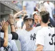  ?? Julio Cortez / Associated Press ?? The Yankees’ Giancarlo Stanton, center, is congratula­ted after hitting a solo home run off Toronto Blue Jays starting pitcher Sean Reid-Foley during the fourth inning on Saturday.