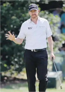  ?? TONY GUTIERREZ/THE ASSOCIATED PRESS ?? Jimmy Walker reacts after making a birdie putt during the opening round of play at the PGA Championsh­ip. Walker shot a 65 on Thursday to take the first-round lead.