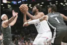  ?? MARY ALTAFFER — THE ASSOCIATED PRESS ?? Philadelph­ia 76ers center Joel Embiid (21) goes to the basket against Brooklyn Nets guard D’Angelo Russell (1)and forward Jared Dudley during the first half of Game 4 of a first-round NBA basketball playoff series, Saturday in New York.