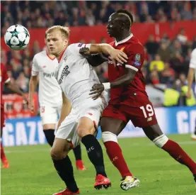  ??  ?? Liverpool's Sadio Mane, right, fights for the ball with Sevilla's Johannes Geis