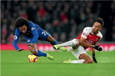  ?? GETTY IMAGES ?? Chelsea’s Willian is sent tumbling during a challenge by Arsenal’s Pierre-Emerick Aubameyang during the Premier League match at Emirates Stadium yesterday.