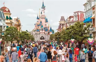  ??  ?? In this file photo, visitors walk near Sleeping Beauty's Castle at Disneyland Paris, in Marne la Vallee, east of Paris. — AP