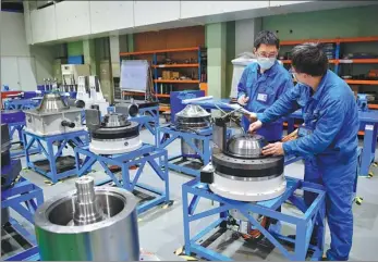  ?? SHAO RUI / XINHUA ?? Technician­s work at a machine tool making company in Baoji, Shaanxi province.