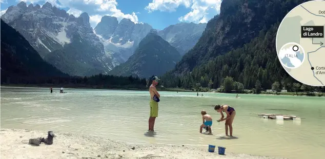  ?? (foto di Massimo Spampani) ?? In riva
Turisti con i piedi in acqua o stesi per la tintarella al lago di Landro, a circa 20 chilometri da Cortina D’ampezzo