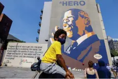  ?? (EPA) ?? Blair Rankin, six, sits on his father’s shoulders as people gather round a mural of Lewis in Atlanta, Georgia, yesterday