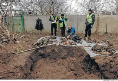  ?? ROMAN PILIPEY / EFE ?? Un forense inspeccion­a los restos de seis cuerpos tras su exhumación de una fosa común en las afueras de Jerson.