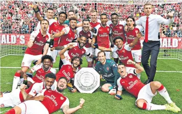  ??  ?? Silver service: Arsenal’s players show what winning the Community Shield means to them after their penalty success at Wembley