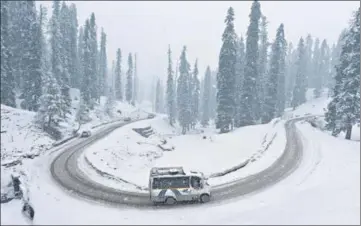  ?? WASEEM ANDRABI/HT ?? A vehicle plying on a snow-covered road near Gulmarg on Sunday.