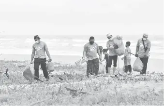  ?? — Gambar Bernama ?? GOTONG-ROYONG: Sukarelawa­n Geng Plastik Ija (GPI) memungut pelbagai jenis sampah sarap seperti botol plastik di sekitar pantai ketika ditemui di Pantai Pandak, Kuala Terengganu baru-baru ini.