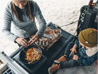  ??  ?? Food always tastes best when cooked in the great outdoors with family and friends.