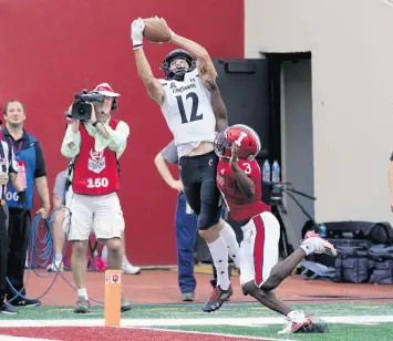  ?? DARRON CUMMINGS/AP ?? Cincinnati’s Alec Pierce makes a touchdown catch against Indiana’s Tiawan Mullen during the second half on Saturday.