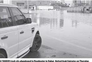  ?? AP/JON GAMBRELL ?? A TANKER truck sits abandoned in floodwater in Dubai, United Arab Emirates on Thursday, April 18, 2024. The United Arab Emirates attempted to dry out Thursday from the heaviest rain the desert nation has ever recorded, a deluge that flooded out Dubai Internatio­nal Airport and disrupted flights through the world’s busiest airfield for internatio­nal travel.