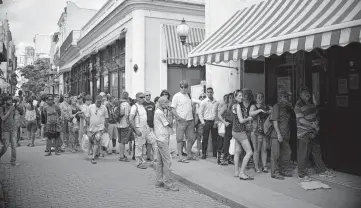  ?? YURI CORTEZ AFP/Getty Images ?? Cubans and tourists lined up outside a Western Union office to receive money orders in Havana, Cuba, on March 19, 2016.