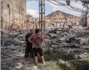  ?? EFE ?? Luhansk .- Vecinos observan los edificios destruidos en Lysychansk tras intensos combates.