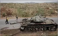  ?? ?? Farmers walk past an abandoned army tank in Tigray.