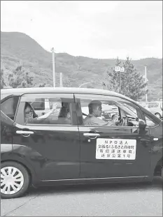  ??  ?? A tourist from pingapore (left), who is the first user of the car sharing service supported by rber in hyotango, waves from the car in hyotango, hyoto prefecture, gapan jay 2SK — oeuters photo