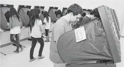  ?? Alan Warren / Houston Chronicle ?? Bellaire High School freshman William Faour cast his votes for the school’s student election using voting equipment from an initiative by Harris County Clerk Stan Stanart’s office. The equipment provided students with a real voting experience.