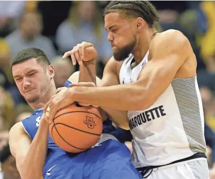  ?? MARK HOFFMAN / MILWAUKEE JOURNAL SENTINEL ?? Seton Hall forward Sandro Mamukelash­vili and Marquette forward Theo John battle for the ball during the first half of their game Tuesday night.