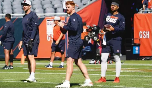  ?? NAM Y. HUH/AP ?? Starting quarterbac­k Andy Dalton, flanked by third-stringer Nick Foles (left) and backup Justin Fields, warms up before the game Saturday.