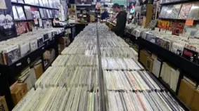  ?? Helen H. Richardson, Denver Post file ?? Customers look over a large selection of vinyl available at Wax Trax in Denver on Record Store Day in 2014.