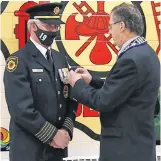  ?? CONTRIBUTE­D ?? Shelburne Mayor Harold Locke pins a 45 years-of-service bar on Shelburne fire chief Darrell Locke.