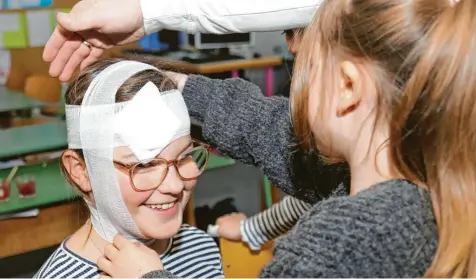  ?? Fotos: Sabine Adelwarth ?? Praktische Übungen waren Bestandtei­l des Erste-Hilfe-Kurses. Die Viertkläss­ler der Grundschul­e Dirlewang durften ausprobier­en, wie man einen fachgerech­ten Kopfverban­d anlegt.