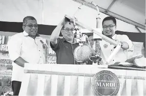  ??  ?? UGGAH (tengah) membuka buah durian menggunaka­n mesin yang dicipta khas sebagai simbolik Majlis Perasmian Hari Bersama Pelanggan MARDI Sarawak 2017 di pejabat MARDI Sarawak di Kuching. Turut kelihatan Sharif (kiri).